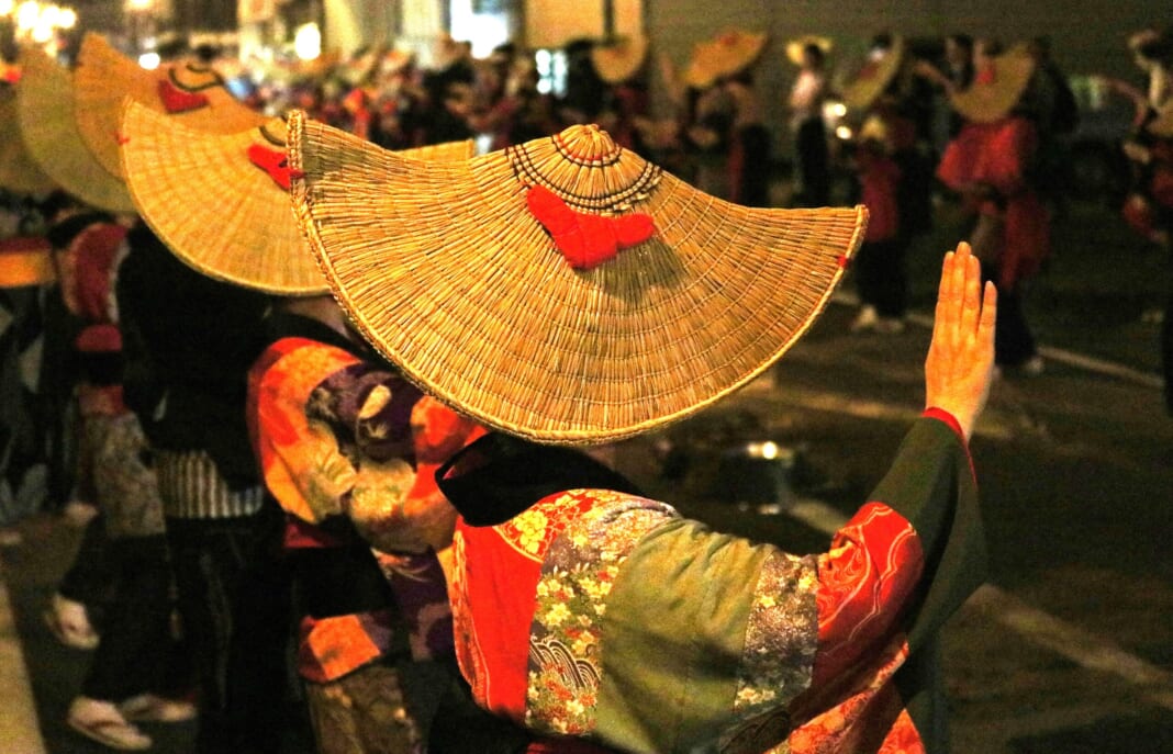大勢の観光客を魅了する西馬音内盆踊り。踊り手のしぐさと、編み笠に端縫い衣装の洗練された美が人々を引き付ける