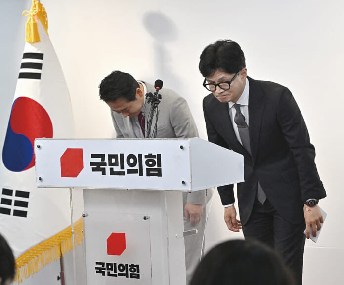 ４月11日、ソウルで行われた記者会見で頭を下げる韓国与党「国民の力」トップの韓東勲非常対策委員長（右）（ＡＦＰ時事）