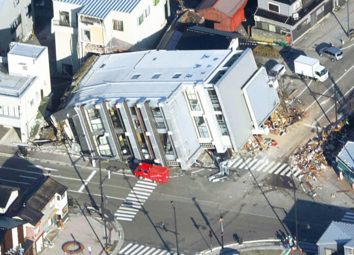地震で倒壊したとみられるビル（中央）＝１月２日、石川県輪島市（時事通信チャーター機から）