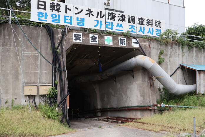 日本語とハングルで「日韓トンネル唐津調査斜坑」と書かれた唐津調査斜坑の坑口＝2024年９月、佐賀県唐津市（竹澤安李紗撮影）