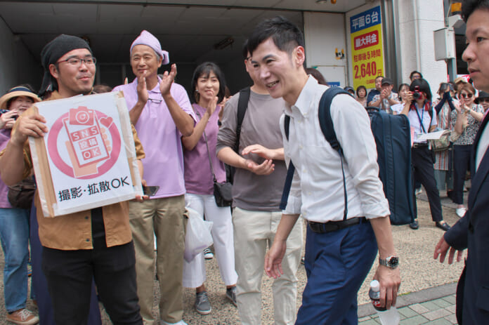 支持者らの拍手の中、演説に向かう石丸伸二氏　＝２０日午前、東京都新宿区