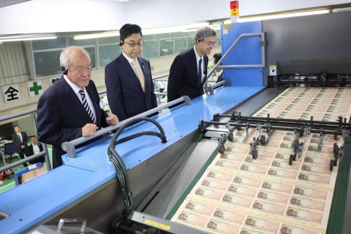 新紙幣の製造工程を視察する鈴木俊一財務相（左）、氷見野良三日本銀行副総裁（右）ら＝６月28日、東京都北区（国立印刷局提供）