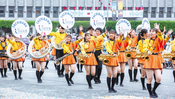 2022年10月10日、台北市で台湾総統府前で行われた双十節（建国記念日）式典の祝賀パレードで、観衆に笑顔で手を振る京都橘高校吹奏楽部のメンバーたち（台湾総統府提供・時事）