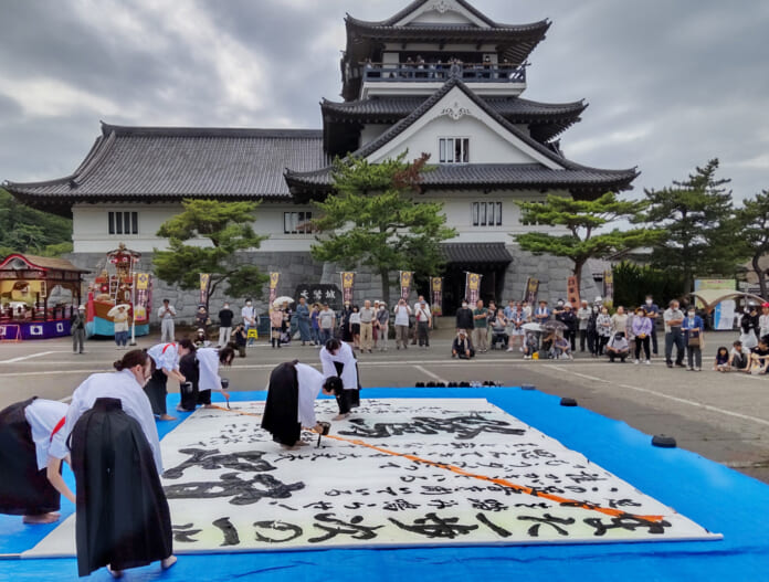 観光用に建てられた天鷺城　旧藩祭では広場で書道パフォーマンスも行われた