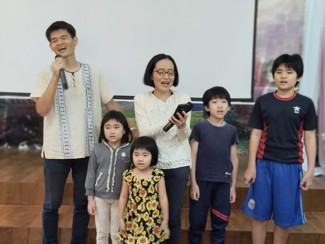 アスンシオンの教会のクリスマス礼拝で家族とスペイン語の歌を歌う